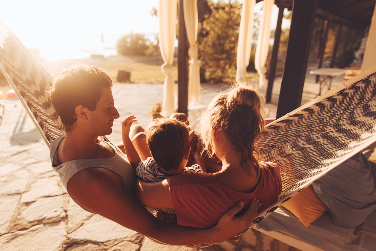 Eine Familie sitzt in einer Hängematte.
